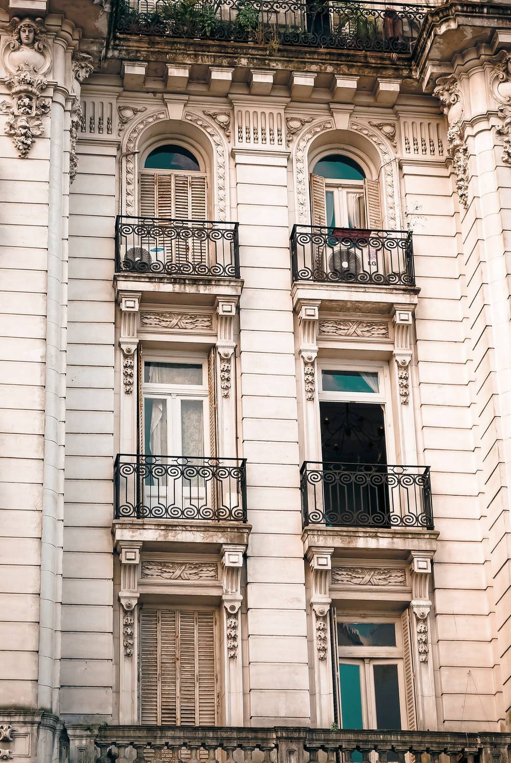 Fachada de un edificio antiguo de Buenos Aires con balcones de hierro y ventanas en arco