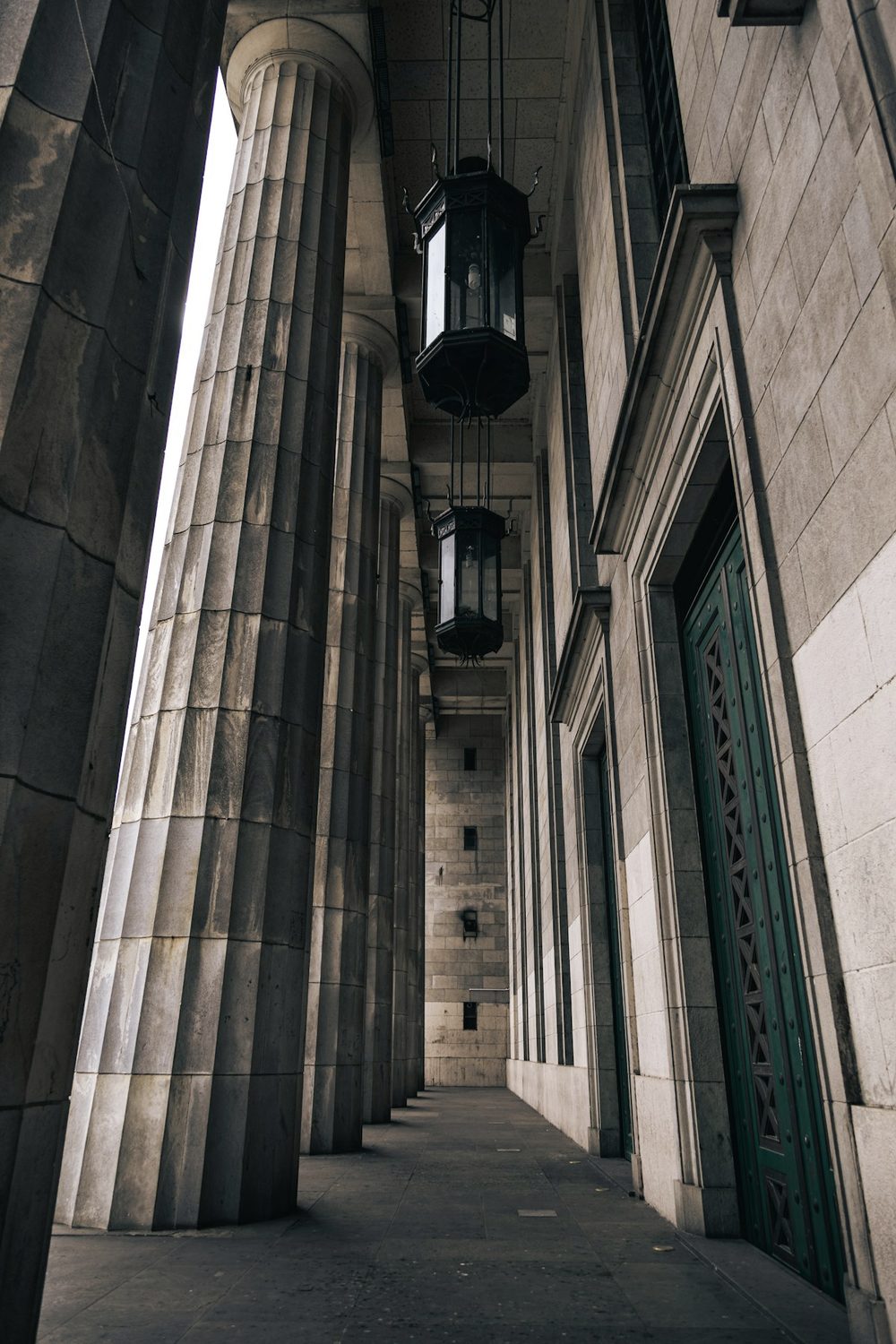 Pórtico de columnas de piedra con faroles de hierro colgantes, en Buenos Aires