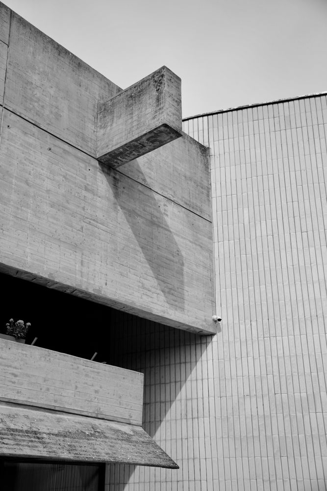 Volúmenes de hormigón y un muro de ladrillo claro, composición geométrica en blanco y negro