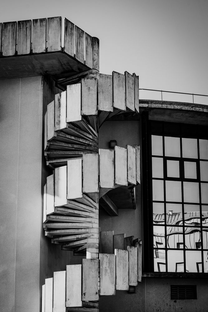Escalera caracol de hormigón vista desde afuera, en blanco y negro