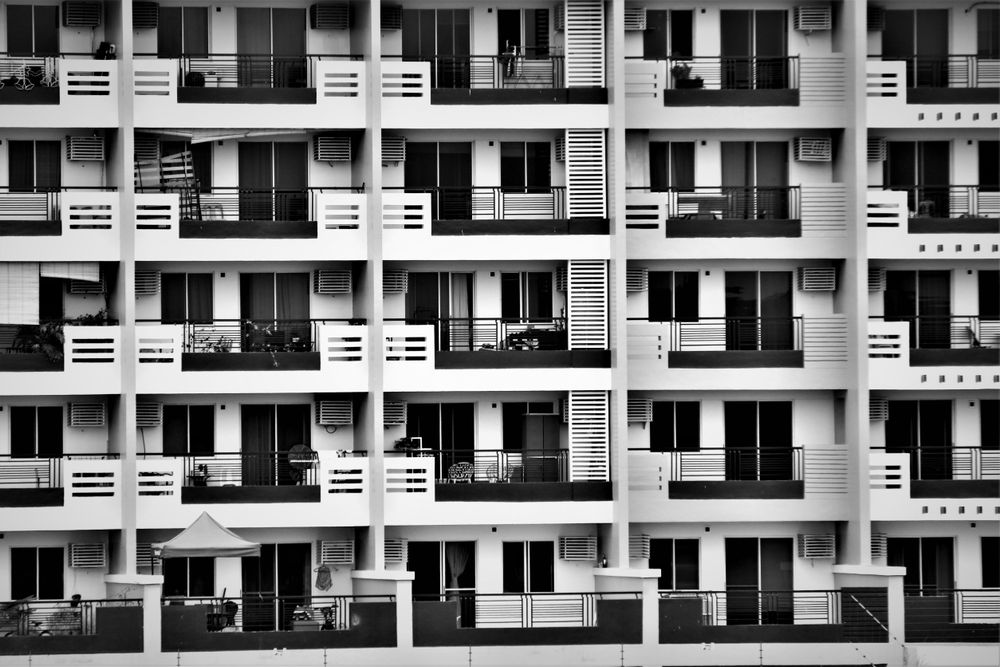 Fachada de un edificio de viviendas con balcones repetidos, en blanco y negro